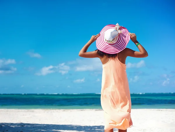 Horký krásný žena v barevné slunečník a šaty chůze v blízkosti pláže oceán v horkém letním dni na bílém písku — Stock fotografie