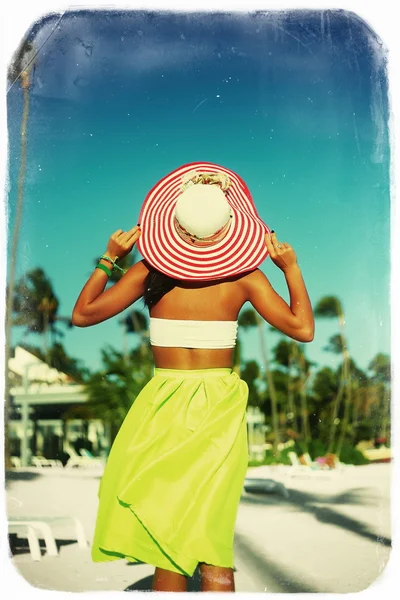 高时尚外观。复古风格与棕榈树在色彩鲜艳的布和遮阳帽背后蓝色海滩天空的魅力性感模特女孩后面 — 图库照片