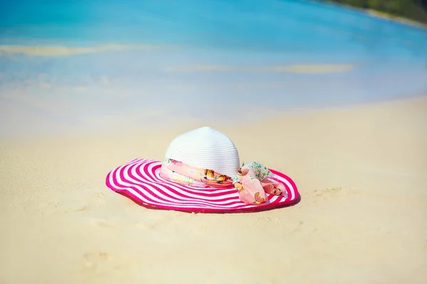 Berwarna cerah topi matahari di pantai pasir di belakang laut biru air musim panas — Stok Foto