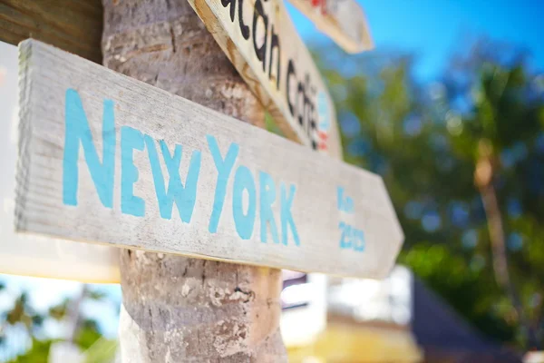 Дорожный знак, включая Нью-Йорк на зеленом тропическом фоне — стоковое фото