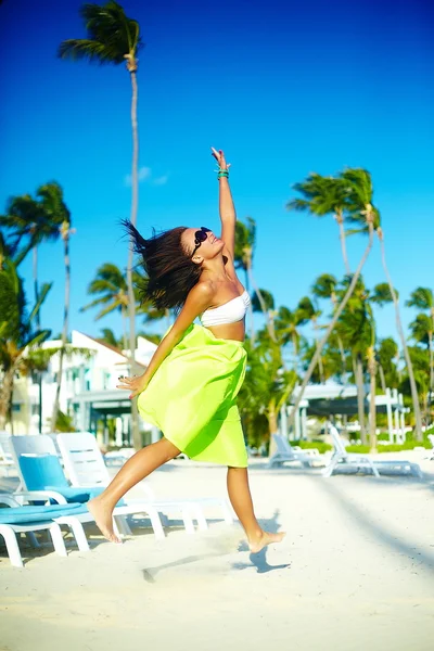 Happy urban modern young stylish woman girl model in bright modern cloth in green colorful skirt outdoors in the summer beach jumping behind blue sky — Stock Photo, Image