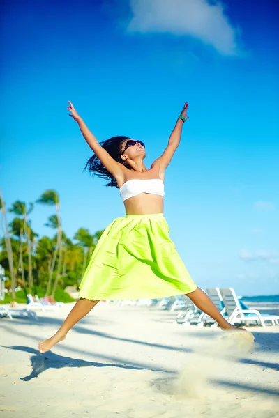 Šťastný městské moderní elegantní mladá dívka model v světlé moderní tkaniny v zelené barevné sukně venku v létě beach, skákání za modré oblohy — Stock fotografie