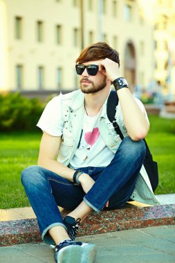Komik gülümseyen hipster yakışıklı çocuk güneş gözlüğü sokakta şık kumaş