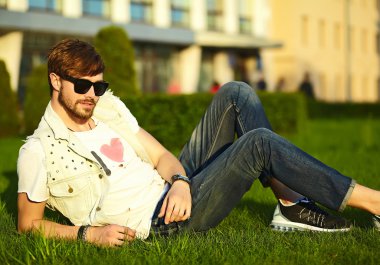 Komik gülümseyen hipster yakışıklı çocuk güneş gözlüğü sokakta şık kumaş