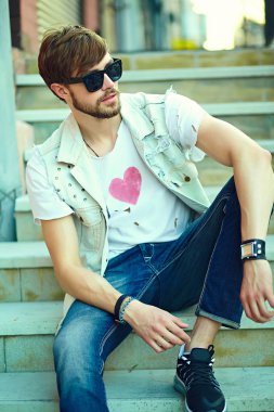 Komik gülümseyen hipster yakışıklı çocuk güneş gözlüğü sokakta şık kumaş