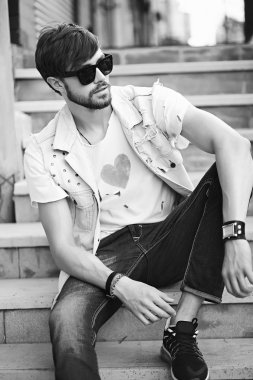 Komik gülümseyen hipster yakışıklı çocuk güneş gözlüğü sokakta şık kumaş