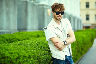 Komik gülümseyen hipster yakışıklı çocuk güneş gözlüğü sokakta şık kumaş