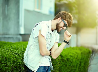 Komik gülümseyen hipster yakışıklı çocuk güneş gözlüğü sokakta şık kumaş