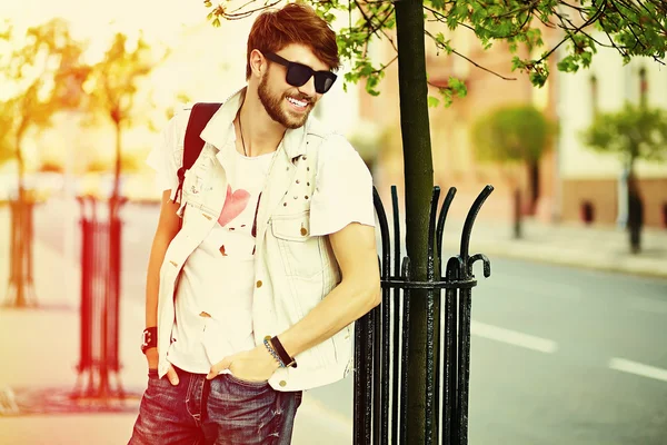 Usmívající se bederní pohledný muž vtipnej v elegantní tkaniny v ulici sluneční brýle — Stock fotografie