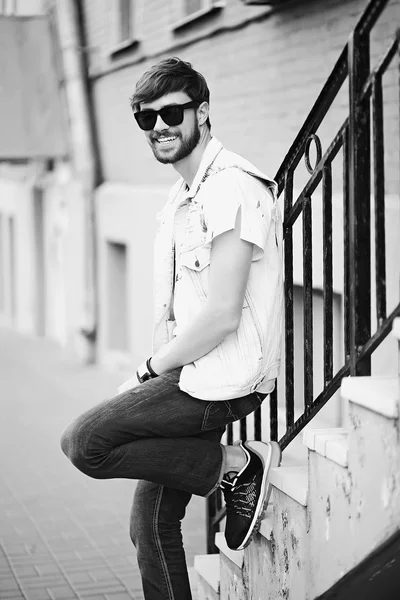 Engraçado sorrindo hipster homem bonito cara em pano elegante na rua em óculos de sol — Fotografia de Stock