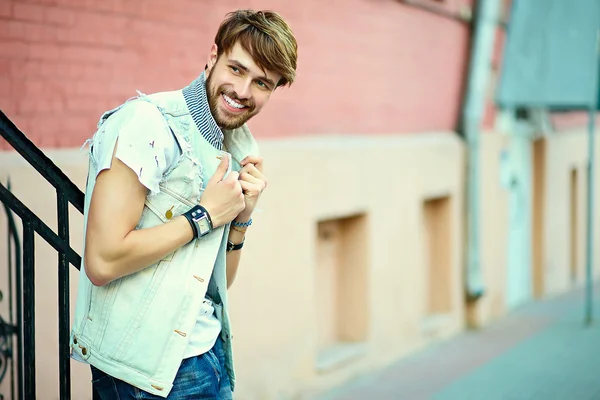 Funny smiling hipster handsome man guy in stylish cloth in the street in sunglasses