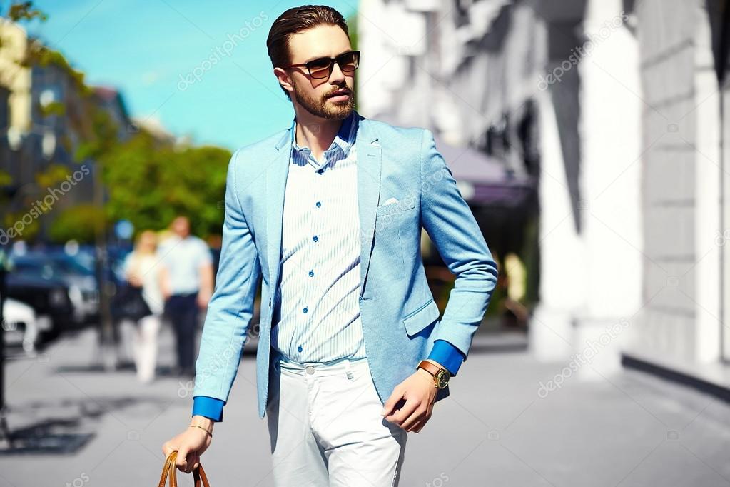 High fashion look.Young stylish confident happy handsome businessman model  in suit cloth lifestyle in the street in sunglasses