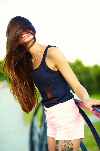 Funny élégant sexy souriant beau modèle de jeune femme ensoleillée en été tissu hipster lumineux dans le parc — Photo