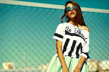 Funny crazy glamor stylish sexy smiling beautiful young woman model in  bright hipster summer casual cloth sitting  in the street behind blue sky