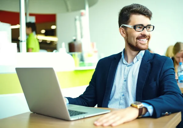 Young fashion smiling hipster man drinking  coffee in the city cafe during lunch time with notebook in suit — Stockfoto