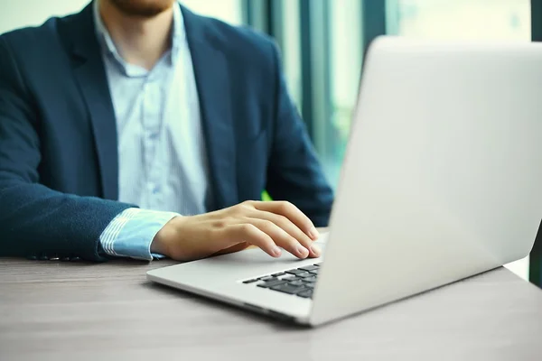 Fiatal ember dolgozik a laptop, a notebook számítógép férfi kezét, a vállalkozó a munkahelyen — Stock Fotó
