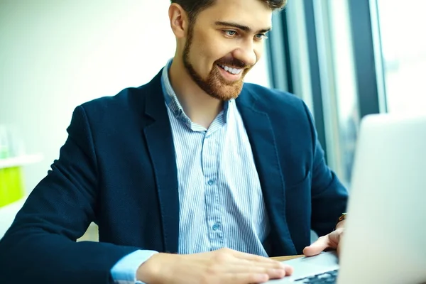 Young fashion smiling hipster man drinking  coffee in the city cafe during lunch time with notebook in suit — Stock fotografie