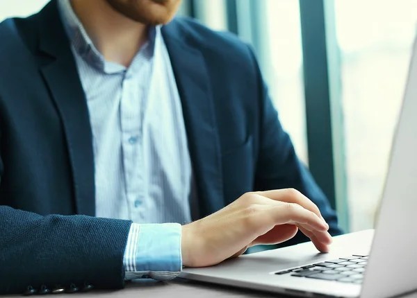 Young man working with laptop, man's hands on notebook computer, business person at workplace — Stock Photo, Image