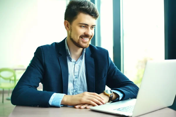 Young fashion smiling hipster man drinking  coffee in the city cafe during lunch time with notebook in suit — Stockfoto