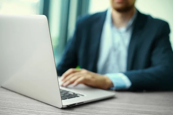 Young man working with laptop, man's hands on notebook computer, business person at workplace — Stock Photo, Image