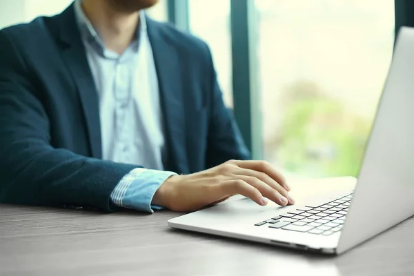 Jovem trabalhando com laptop, mãos de homem no computador notebook, pessoa de negócios no local de trabalho — Fotografia de Stock