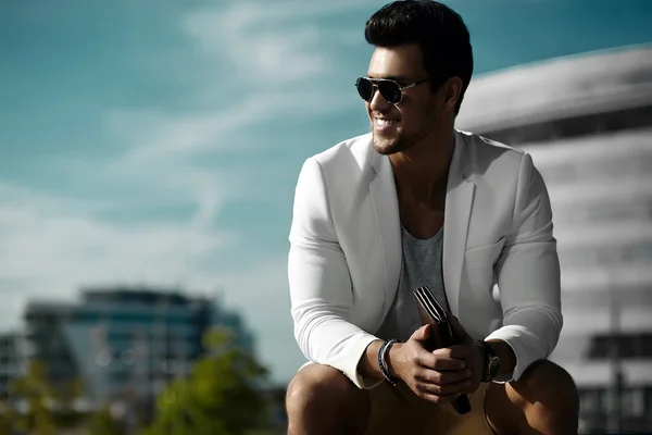 Retrato de moda de hombre de negocios sexy joven modelo guapo en traje de tela casual en gafas de sol en la calle — Foto de Stock