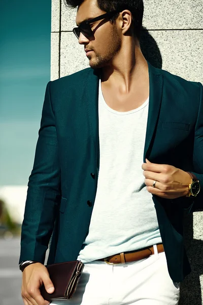 Ritratto di moda di giovane uomo d'affari sexy bel modello uomo in abito di stoffa casual in occhiali da sole in strada dietro il cielo blu — Foto Stock