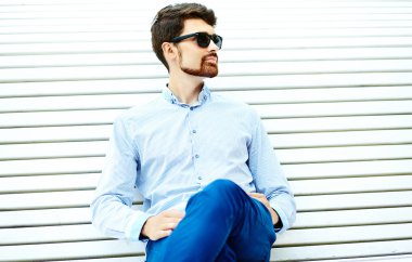 Young handsome hipster Male Student Sitting on the Bench in a Park