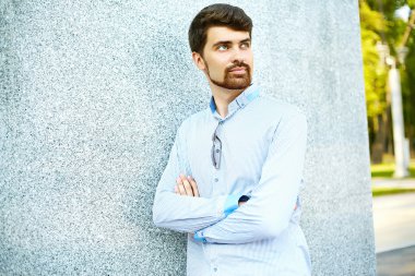 Young handsome hipster Male Student standing near wall