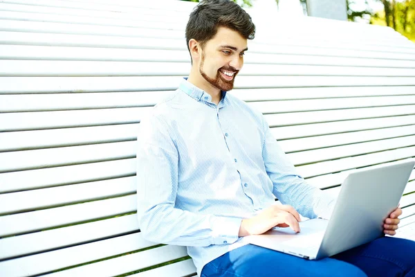 Young man working with laptop, man's hands on notebook computer, business person in casual clothes in the street — Stock Photo, Image
