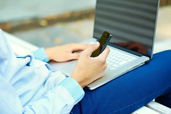 Молодий чоловік працює з ноутбуком, руки людини на ноутбуці, бізнесмен в повсякденному одязі на вулиці — стокове фото