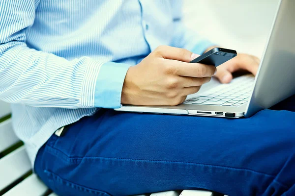 Young man working with laptop, man's hands on notebook computer, business person in casual clothes in the street — Stock Photo, Image