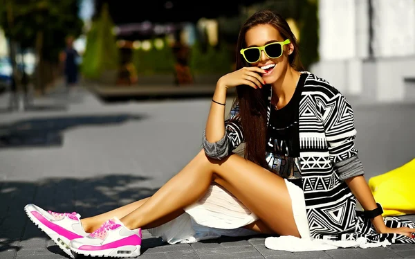 Moda glamour engraçado elegante sexy sorrindo bela jovem modelo em roupas de verão hipster sentado na rua com compras saco amarelo brilhante — Fotografia de Stock