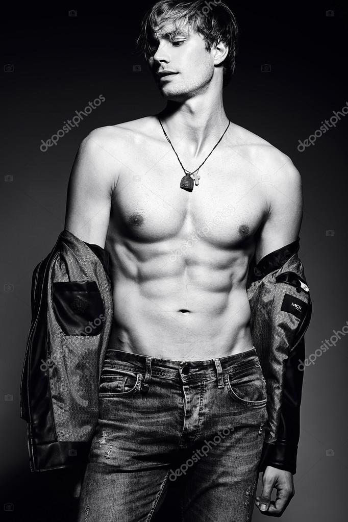 Young handsome muscled fit male model man posing in studio showing his ...