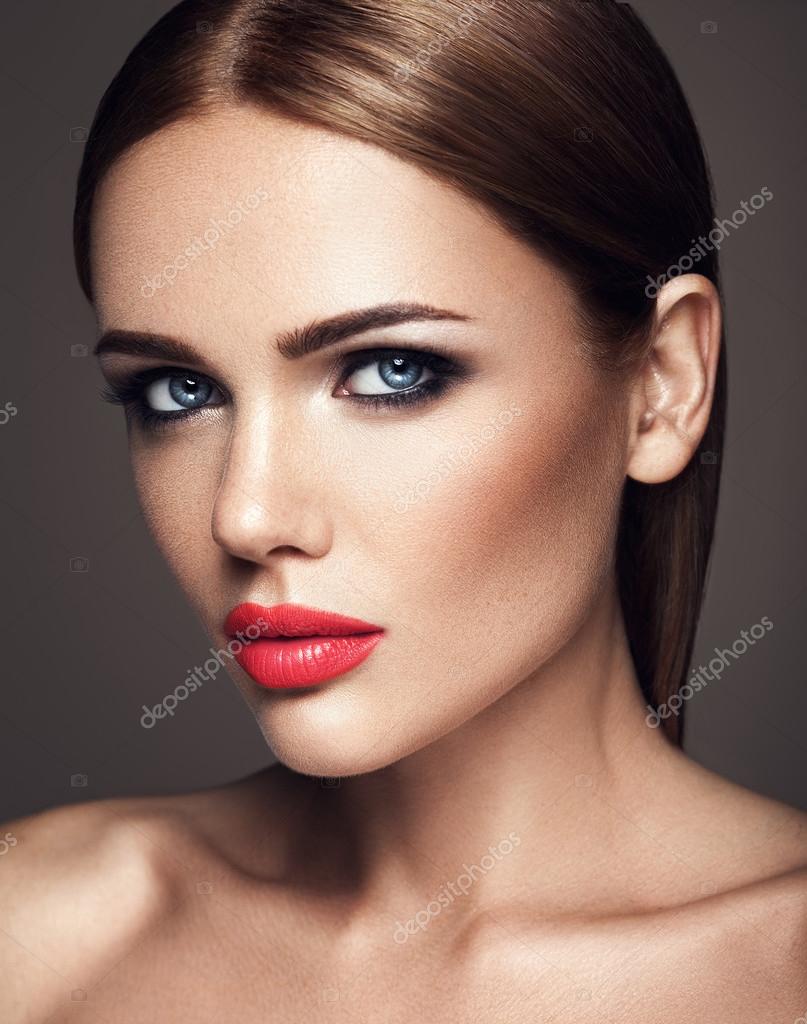 Retrato do modelo de menina bonita com maquiagem de noite e penteado  romântico, tocando a pele dela. lábios rosados