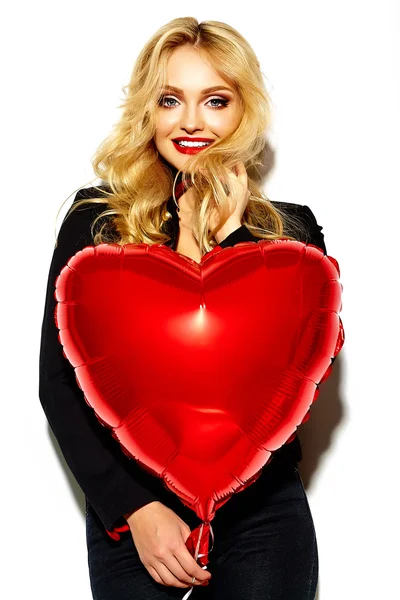 Portrait of beautiful happy sweet smiling blonde woman girl holding in her hands red heart balloon in casual black hipster clothes — Stock Photo, Image