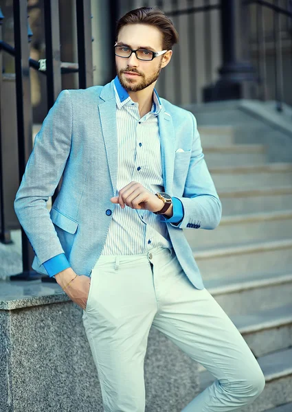 High fashion look.Young stylish confident handsome businessman model in suit clothes lifestyle in the street looking at his watches — Stock Photo, Image