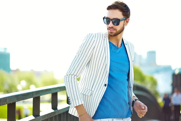 Model mladé stylové jistý šťastný pohledný podnikatel v obleku bederní oblečení chůzi na ulici v sluneční brýle — Stock fotografie