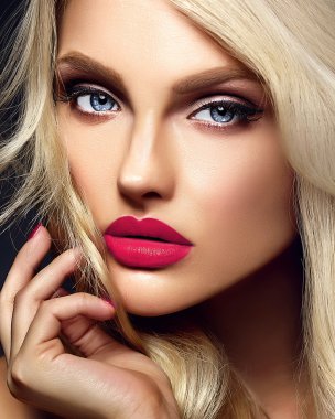 güzel sarışın kadın modeli Bayan parlak makyaj ve siyah arka plan üzerine sağlıklı kıvırcık saçlı pembe dudakları şehvetli glamour portresi