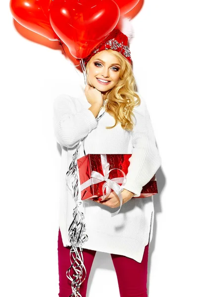 Retrato de hermosa mujer rubia sonriente dulce feliz sosteniendo en sus manos gran caja de regalo de Navidad en ropa de invierno hipster rojo casual, en suéter blanco cálido —  Fotos de Stock