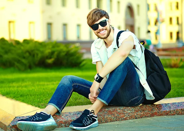 Zabawny uśmiechający się facet przystojny mężczyzna hipster w lato stylowe ubrania na ulicy — Zdjęcie stockowe