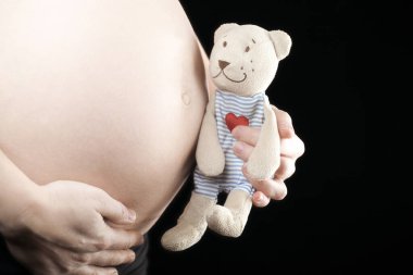 Hamile kadın resmi. El oyuncağı koyu arka plan.