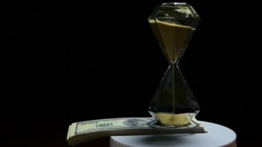footage of sand clock money dark background 