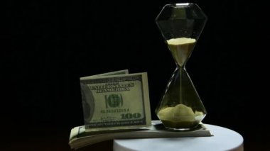 footage of sand clock money dark background 