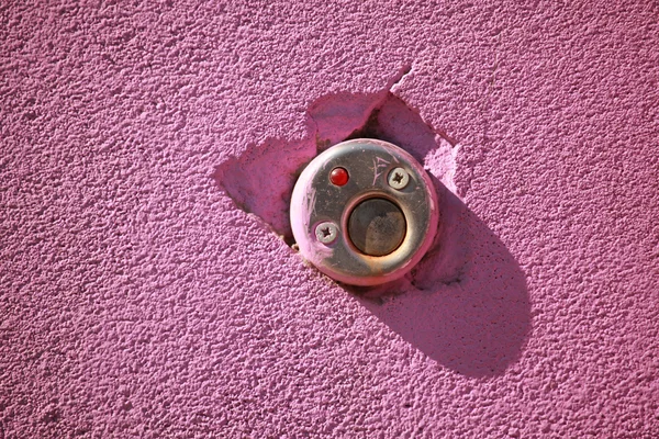 Кнопка на фоне розовой стены — стоковое фото