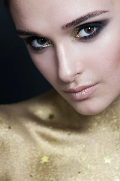 Kobieta z makijażu i złoty skóry. Zbliżenie twarzy — Zdjęcie stockowe