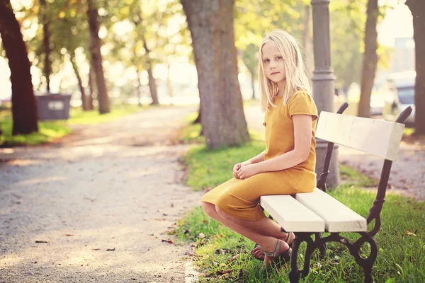 Chica joven sentada en un banco —  Fotos de Stock