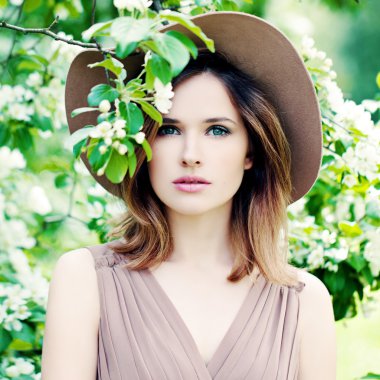 Bahar kadın elma çiçeği arka plan üzerinde şapkalı