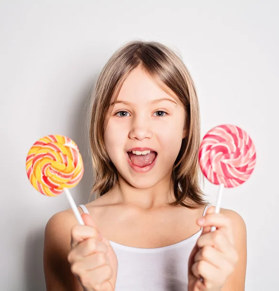 Menina feliz segurando pirulitos — Fotografia de Stock