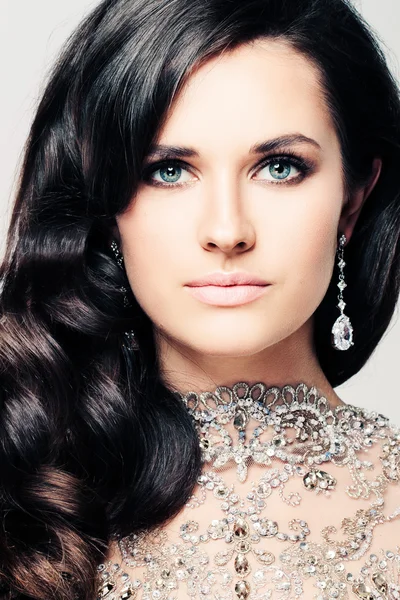 Mooie vrouw met krullend haar en sieraden diamanten oorbellen — Stockfoto